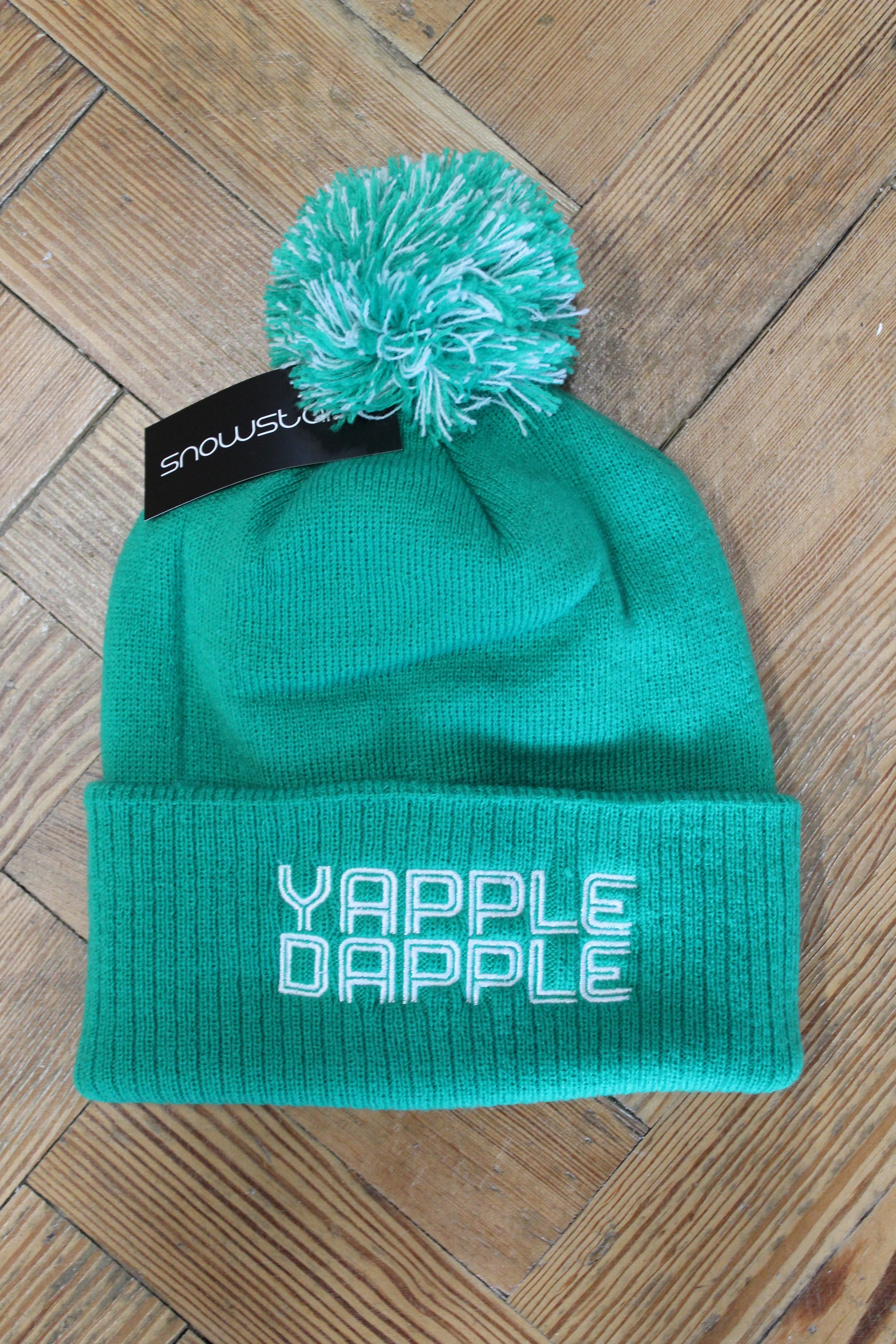 Green Yapple Dapple Beanie with a green and white two-tone bobble